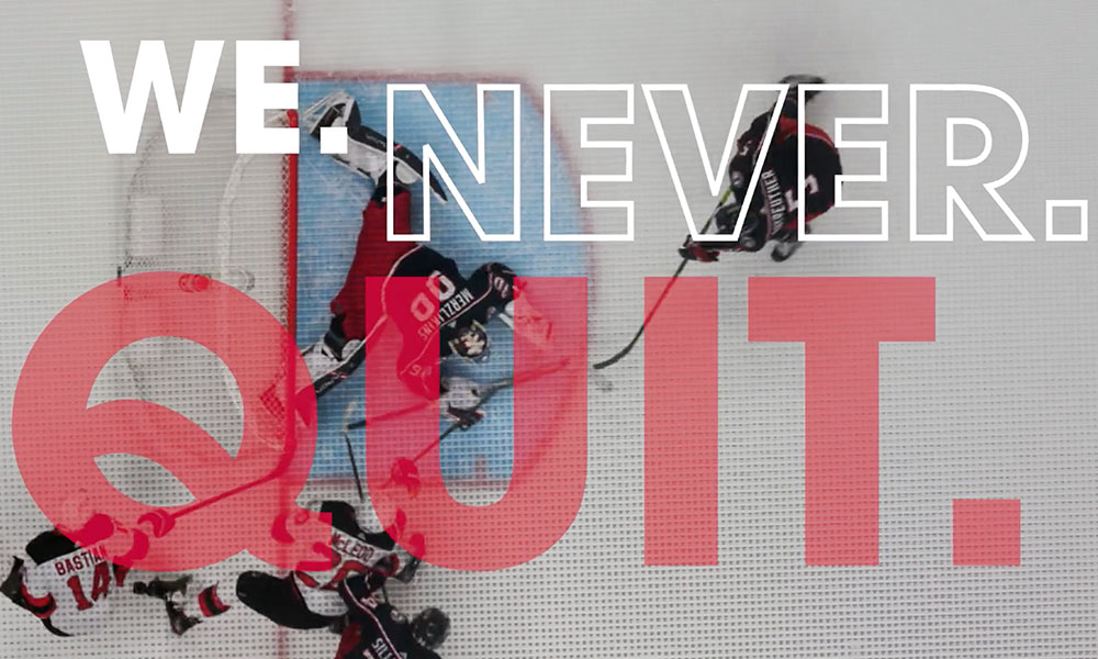 Graphic with the text 'WE. NEVER. QUIT.' in large letters overlaid on a hockey action scene.