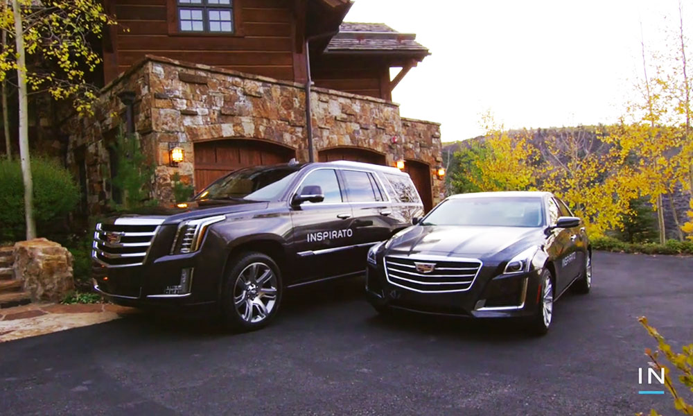 Photo of two 'Inspirato' branded Cadillacs parked in front of a home